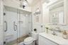 Bathroom featuring tile walls, vanity, and a shower stall