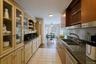 Kitchen featuring glass insert cabinets, dishwasher, open shelves, light tile patterned flooring, and decorative light fixtures