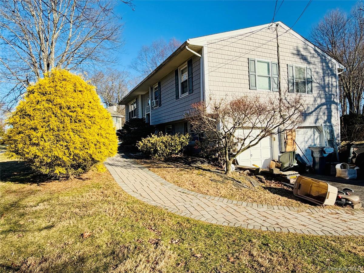 View of side of home with a lawn and an attached garage