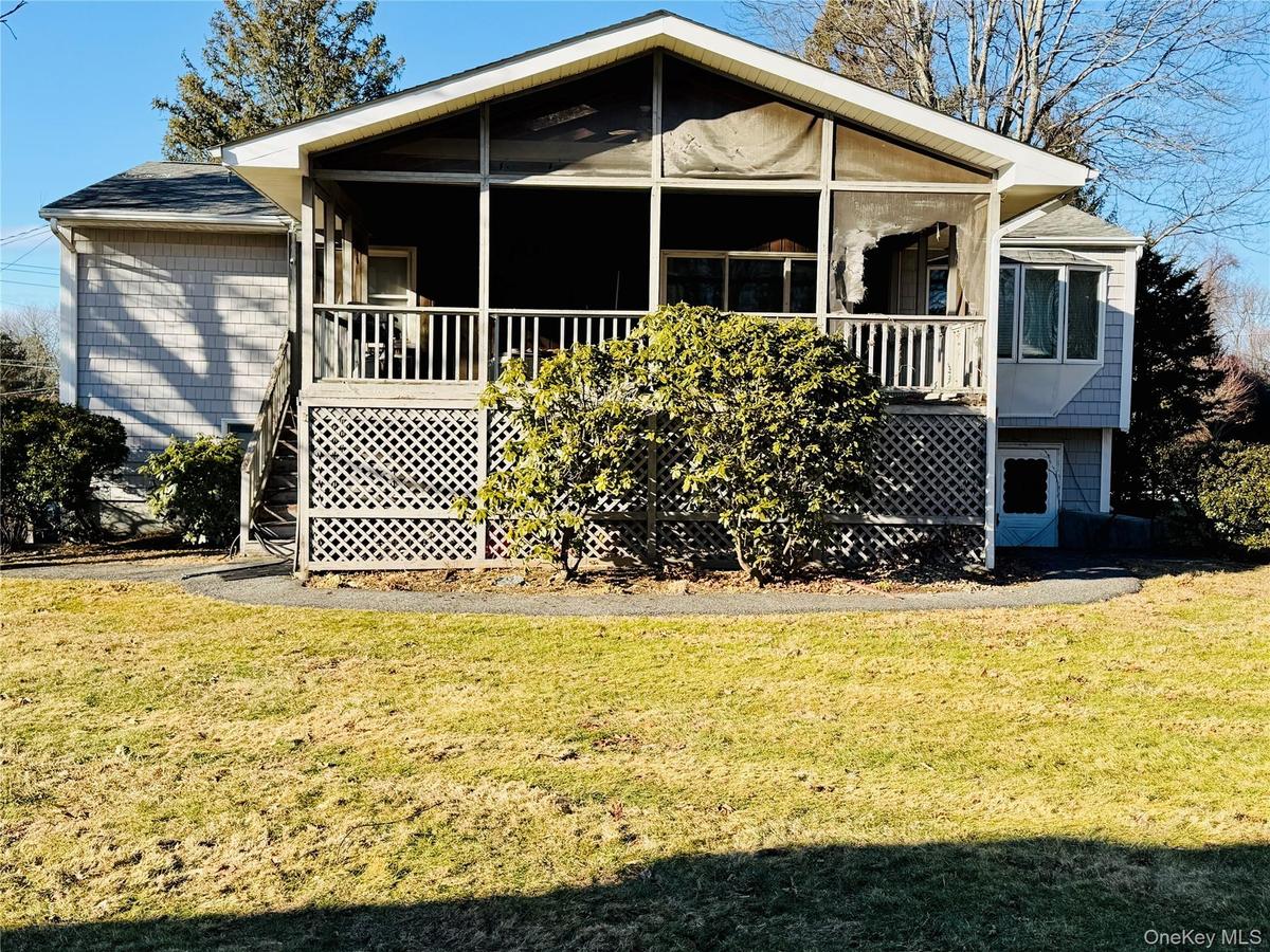 Back of house with a yard and covered porch