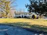 Raised ranch featuring a chimney and a front yard