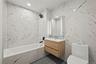Full bathroom with tile walls, vanity, recessed lighting, and dark tile patterned flooring