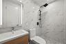 Full bathroom featuring tile walls, a marble finish shower, vanity, and recessed lighting