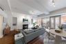 Living area featuring beam ceiling, dark wood-type flooring, a glass covered fireplace, and built in features