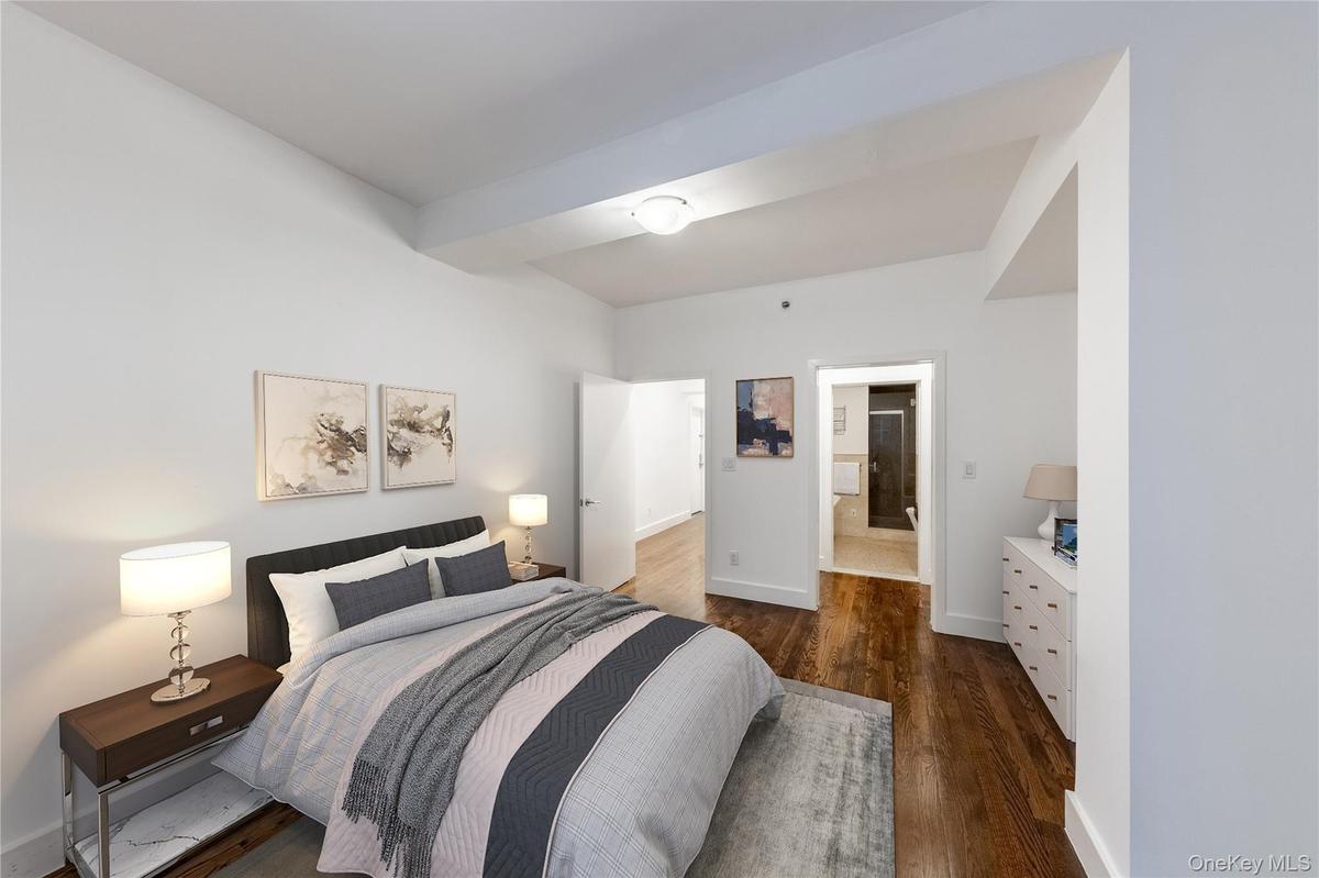 Bedroom with dark wood-type flooring and ensuite bath