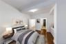 Bedroom with dark wood-type flooring and ensuite bath