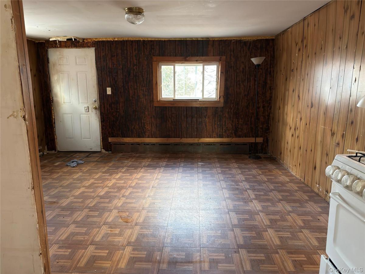 Spare room with wood walls and a baseboard heating unit