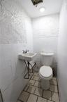 Bathroom with tile walls, light tile patterned floors, and wainscoting