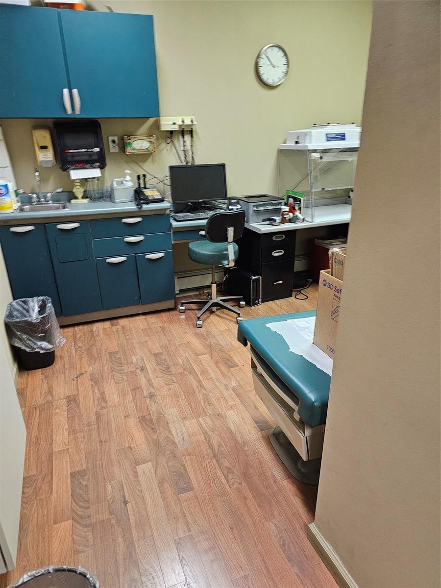 Office with light wood-type flooring and a sink