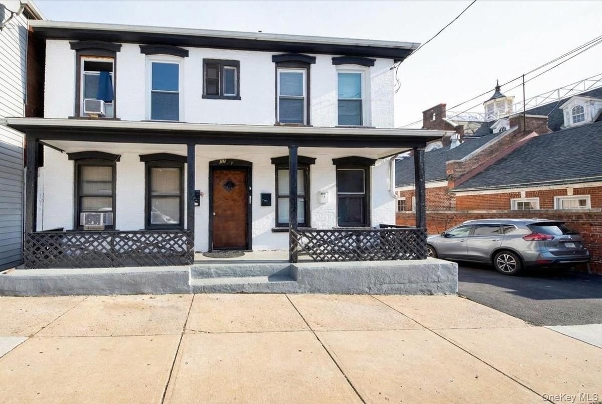View of front of house featuring covered porch and brick siding