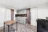 Kitchen with black gas range, gray cabinetry, light stone counters, and tasteful backsplash