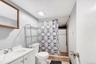 Full bathroom featuring curtained shower, vanity, and light tile patterned floors