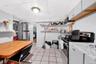 Kitchen with stainless steel appliances, light countertops, light tile patterned floors, white cabinets, and open shelves