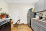 Kitchen featuring gray cabinetry, light countertops, light wood-type flooring, a paneled ceiling, and freestanding refrigerator