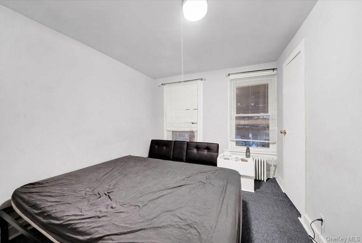 Carpeted bedroom with radiator