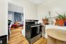 Kitchen featuring a drop ceiling, electric range, and light wood-style floors