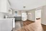 Eat-in Kitchen with backsplash, white appliances, gray cabinets, under cabinet range hood, and white cabinets