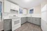 Eat-in Kitchen with gray cabinets, white appliances, under cabinet range hood, white cabinets, and tasteful backsplash