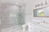 Bathroom with a marble finish shower, light marble finish flooring, vanity, and recessed lighting