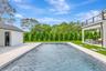 Outdoor pool with a patio and a lawn