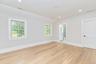 Unfurnished bedroom with light wood-style floors, recessed lighting, ensuite bath, and lofted ceiling