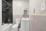 Full bath with vanity, a wainscoted wall, tile walls, tub / shower combination, and tile patterned floors