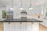 Kitchen featuring crown molding, tasteful backsplash, light wood-style floors, dark stone counters, and recessed lighting