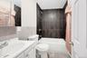 Bathroom featuring vanity, shower / bath combination with curtain, tile walls, a wainscoted wall, and light tile patterned floors