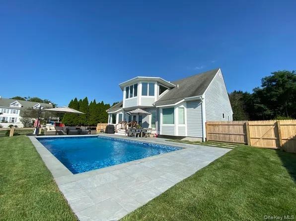 Rear view of house with an outdoor living space, patio area and pool.