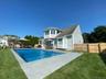 Rear view of house with an outdoor living space, patio area and pool.