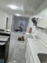 Kitchen featuring light stone counters and white cabinetry