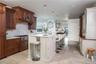 Kitchen featuring a breakfast bar area, a kitchen island with sink, hanging light fixtures, and wooden ceiling