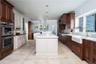 Kitchen with wood ceiling, an island with sink, hanging light fixtures, stainless steel appliances, and sink