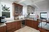 Kitchen featuring wine cooler, light stone counters, and light wood-type flooring