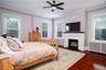 Bedroom with radiator, ceiling fan, multiple windows, and dark hardwood / wood-style flooring