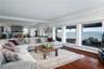 Living room with baseboard heating, ornamental molding, a water view, and dark hardwood / wood-style flooring