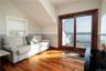 Living room featuring lofted ceiling, hardwood / wood-style floors, and a water view