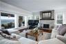 Living room with a water view, hardwood / wood-style flooring, baseboard heating, and plenty of natural light