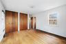 Unfurnished bedroom featuring wood-type flooring, multiple closets, and radiator heating unit