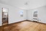 Unfurnished bedroom featuring light wood-style flooring and radiator heating unit