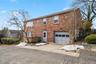 Colonial home featuring brick siding, a garage, and concrete driveway