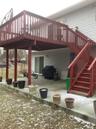 Snow covered patio featuring area for grilling and a wooden deck