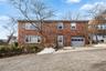 View of front of house with brick siding, an attached garage, and driveway