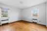 Spare room featuring radiator, light wood-type flooring, and plenty of natural light