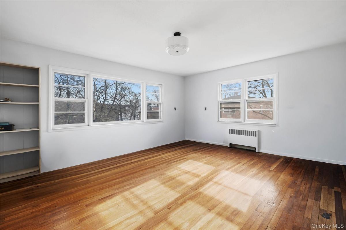 Unfurnished room featuring radiator and hardwood / wood-style flooring