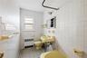 Full bathroom featuring a bath, radiator, tile walls, light tile patterned floors, and wainscoting