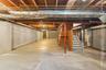 Unfinished basement with stairs and heating unit