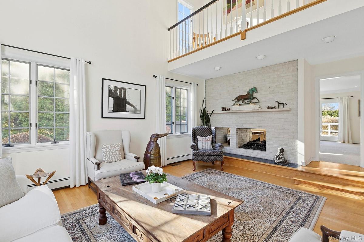 Living area with a brick fireplace, baseboard heating, and wood finished floors