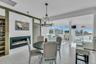 Dining area with a glass covered fireplace, wood ceiling, light wood-style floors, a chandelier, and built in features