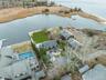 Aerial view of property's location with a large body of water and nearby suburban area